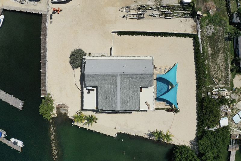 Aerial view of Dolphin Cove's home, pool, beach and dock