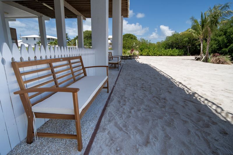 A bench on the soft sand beneath the house