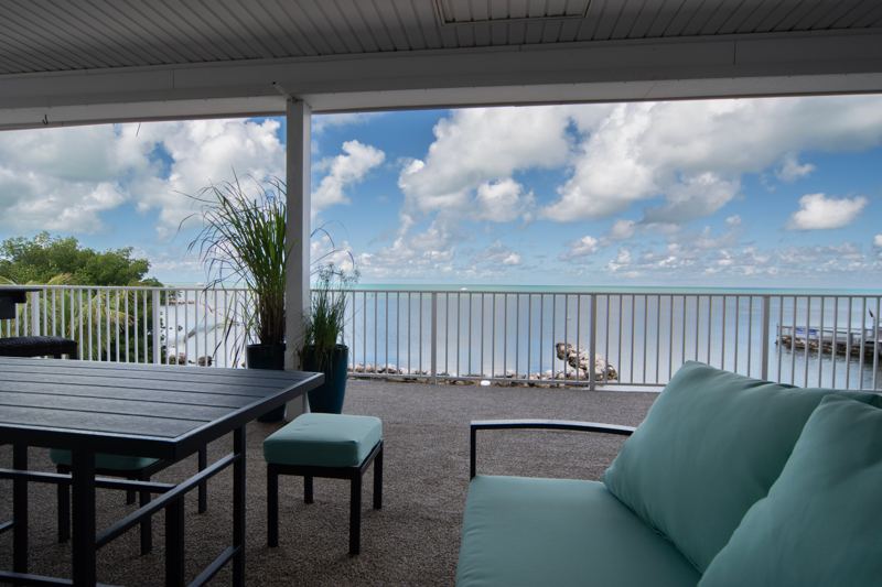 Covered deck with outdoor dining and a view of the Gulf