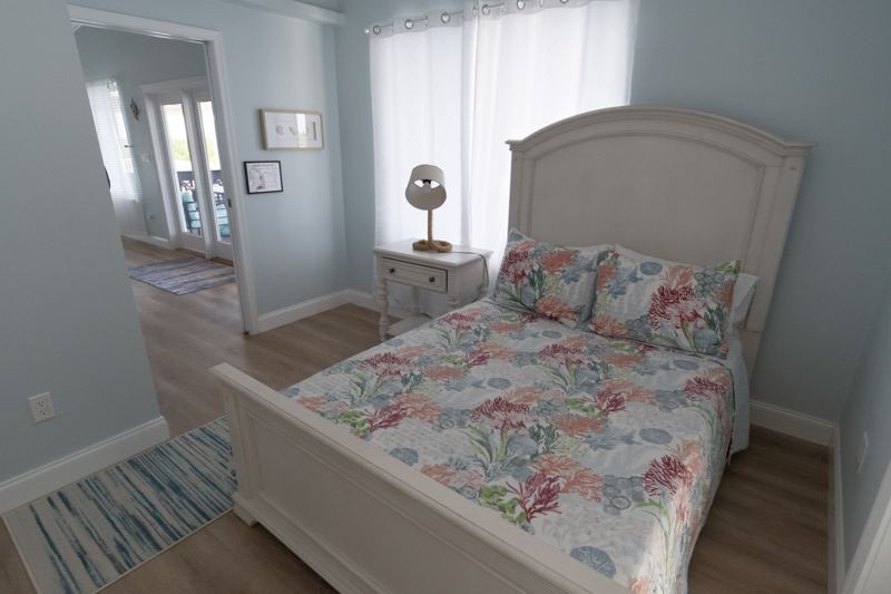 Bedroom with a full bed and floral coastal bedding