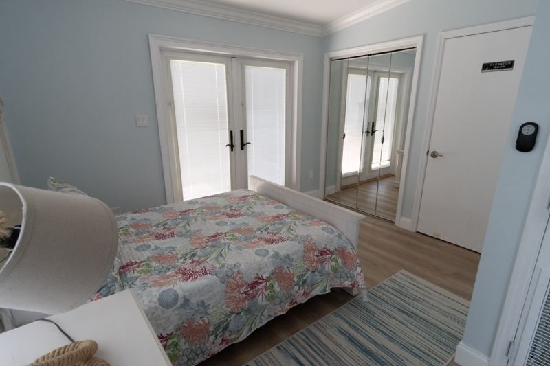 Full bedroom with French doors and a mirrored closet