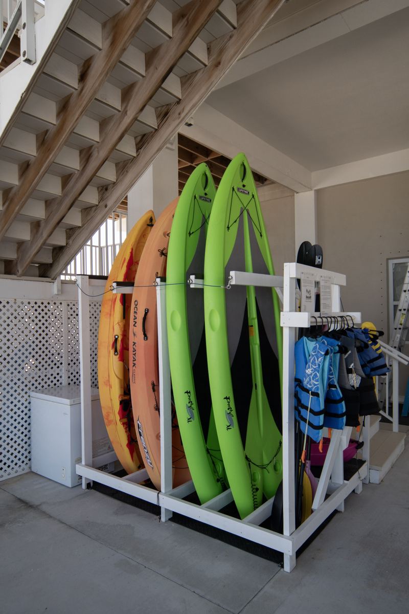 Kayaks, paddleboards and life jackets on the rack beneath the house