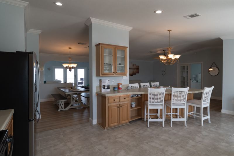 Kitchen breakfast bar with stools and the dining area beyond