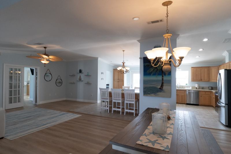 Open living, dining and kitchen area with ceiling fans